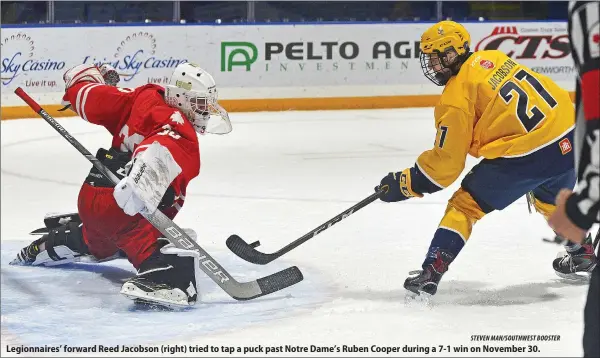  ?? STEVEN MAH/SOUTHWEST BOOSTER ?? Legionnair­es’ forward Reed Jacobson (right) tried to tap a puck past Notre Dame’s Ruben Cooper during a 7-1 win on November 30.