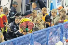  ?? AP ?? Firefighte­rs carry an injured person on a stretcher during carnival celebratio­ns at the Sambadrome in Rio de Janeiro, Brazil, on Sunday.