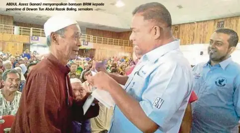  ??  ?? ABDUL Azeez (kanan) menyampaik­an bantuan BRIM kepada penerima di Dewan Tun Abdul Razak Baling, semalam.