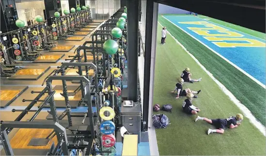  ?? Photograph­s by Wally Skalij Los Angeles Times ?? UCLA OPENED training camp with players stretching out on one of the two artificial turf fields at the new $75-million Wasserman Football Center on campus.