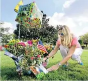  ?? JOE BURBANK/STAFF PHOTOGRAPH­ER ?? Laura Dougherty, a resident at Arnold Palmer’s Bay Hill Golf Club, lays flowers Monday at memorial near the 18th hole.