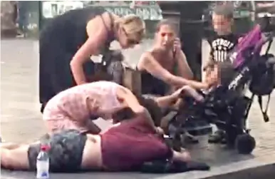  ??  ?? First aid: Tourists tend to an injured man in the street immediatel­y after the attack