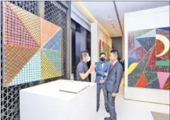  ?? HEAN RANGSEY ?? Pen Robit (right) talks with artist Leang Seckon (left) at Rosewood’s Art Gallery on March 3.