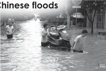  ?? PRESS
ASSOCIATED ?? Residents move a motorcycle on a flooded street in Jiahui town of Gongcheng Yao Autonomous County, southwest China's Guangxi Zhuang Autonomous Region.