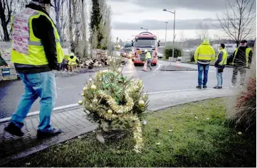  ??  ?? Yellow vest (Gilets jaunes) protestors stand near a Christmas tree as they occupy a traffic circle Near Feyzin Refinery. — AFP photo