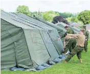  ?? GRAHAM HUGHES FOR NATIONAL POST FILES ?? Members of the Canadian armed forces set up tents to house asylum seekers in Cornwall, Ont., last summer.