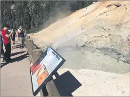  ??  ?? RIGHT: Visitors to Lassen Volcanic National Park take pictures Saturday of a mudpot at the
Sulphur Works.