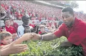  ?? JOHN BAZEMORE — THE ASSOCIATED PRESS ?? Former Georgia running back and Republican candidate for U,S, Senate Herschel Walker greets fans at the Bulldogs’ game Saturday in Atlanta. Later Walker joined former President Donald Trump at a rally.