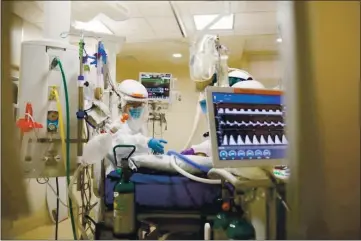  ?? RANDY VAZQUEZ — BAY AREA NEWS GROUP ?? Registered nurses Barbara Callens, left, and Linh Nham, right, treat a patient in the intensive care unit inside El Camino Health Mountain View Hospital in Mountain View on Dec. 22, 2020.