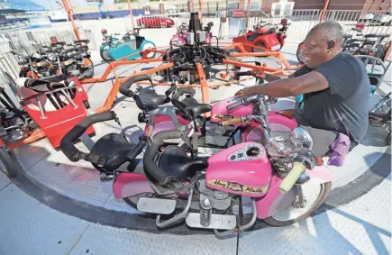  ?? MIKE DE SISTI/MILWAUKEE JOURNAL SENTINEL ?? Jermaine Woodard, with Roses Rides, sets up the Hog Rally ride in Spin City as preparatio­ns take place for the Wisconsin State Fair at State Fair Park in West Allis on Monday.