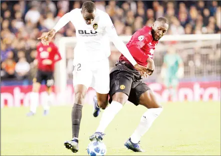  ??  ?? Valencia defender Mouctar Diakhaby (left), duels for the ball with Manchester United’s Eric Bailly during a Group H Champions League soccer matchbetwe­en Valencia and Manchester United at the Mestalla Stadium in Valencia, Spain on Dec 12. (AP)