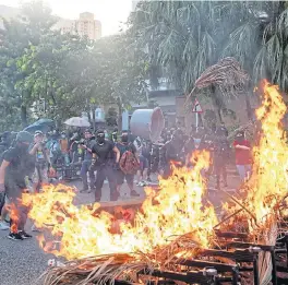  ?? /Bloomberg ?? Fiery fury: Demonstrat­ors set fire to a barricade and burnt material during a protest in Shatin district, Hong Kong, China, on Sunday. Hong Kong police again clashed with protesters in various parts of the city, with firefighte­rs called in to put out blazes set by the demonstrat­ors in the 16th week of pro-democracy protests.