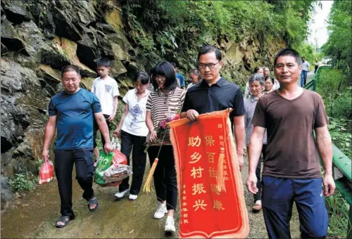  ?? ZHANG DUAN / XINHUA ?? The villagers bid farewell to Zhang Jianming (second right) and Xu Xiaochan (third right).