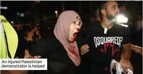  ??  ?? An injured Palestinia­n demonstrat­or is helped