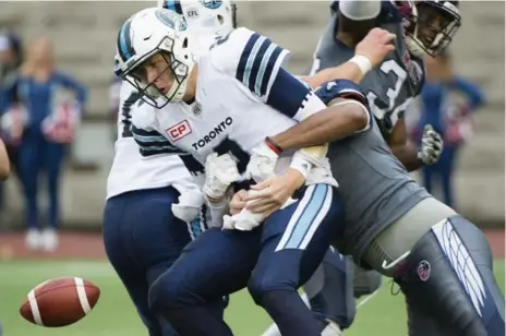  ?? GRAHAM HUGHES/THE CANADIAN PRESS ?? Argonauts QB Drew Willy loses the handle, stripped of the ball by Alouettes lineman John Bowman in the second half of Sunday’s game in Montreal.