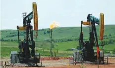  ?? AP ?? Natural gas flares near oil pumps in Watford City, North Dakota. US light crude rose $1.31 a barrel from Friday’s close to a peak of $71.11, its highest since mid-July.