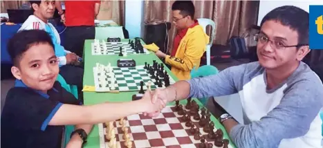 ?? DAN CALICA FACEBOOK ?? END OF STREAK. The winning streak of 13-year-old wonder Daniel Quizon, left, is ended by grandmaste­r (GM) Darwin Laylo in the seventh round of the 10th Kidapawan Open Chess Tournament that closed Sunday at the Kidapawan Convention Center.