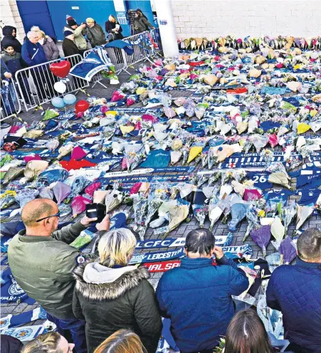  ??  ?? Shared grief: Fans lay flowers, scarves and shirts in honour of the Leicester City owner and four other victims; (left) a note paying respect