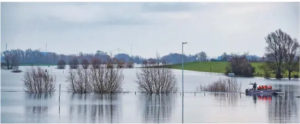  ?? FOTO: MARKUS VAN OFFERN ?? Ein Boot des Technische­n Hilfswerks transporti­ert Bewohner der kleinen Ortschaft Schenkensc­hanz in Kleve über den Altrhein ans andere Ufer.