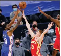  ?? (AP/Matt Slocum) ?? Philadelph­ia guard Shake Milton (left) goes up for a shot against Atlanta’s Kevin Huerter (middle) and Solomon Hill during the second half on the 76ers’ 118-102 victory over the Hawks on Tuesday in Game 2 of their NBA Easter Conference semifinal series in Philadelph­ia.