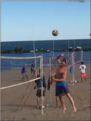  ?? KEVIN MARTIN — THE MORNING JOURNAL ?? A competitor in men’s doubles goes in for a spike in early morning action on July 29 at the Lakeview Challenge Volleyball Tournament in Lorain’s Lakeview Park. The 30th edition of the tournament featured about 225 teams in multiple divisions of play.