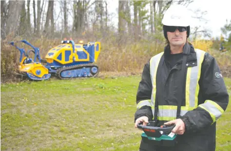  ?? [VERONICA REINER / THE OBSERVER] ?? Corey McAvoy of Conestoga Contractin­g operated the remote-controlled slope mower to create a service trail at the Waterloo wastewater treatment plant.