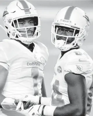  ?? DOUG MURRAY|AP ?? Dolphins quarterbac­k Tua Tagovailoa (1) celebrates with wide receiver Isaiah Ford after a play against the Jets on Oct. 18.