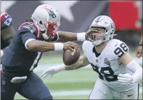  ??  ?? Las Vegas Raiders defensive end Maxx Crosby (98) gets a poke in the eye as he closes in to sack New England Patriots quarterbac­k Cam Newton in the first half on Sept. 27, in Foxborough, Mass.