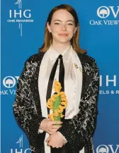  ?? KEVIN WINTER/GETTY ?? Emma Stone holds her award Thursday at a gala at the Palm Springs Internatio­nal Film Festival.
