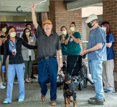  ?? Andrew Rush/Post-Gazette ?? Fred Szoch, 69, walks out of UMPC St. Margaret Hospital in Aspinwall, reuniting with his dog, Brook, after 75 days of battling COVID-19, including 21 days on a ventilator, Monday.