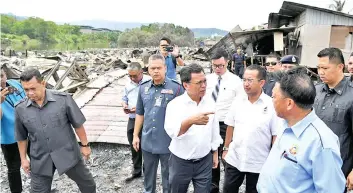  ??  ?? Shafie gestures when visiting the site where almost 200 houses were destroyed in a fire at Kampung Cenderamat­a Dua, Likas on Tuesday.