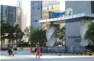  ?? THE ASSOCIATED PRESS ?? A motorist and a pedestrian pass by a building that formerly served as the Flipkart headquarte­rs in Bangalore, India, on Wednesday.