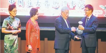  ??  ?? (From right) Fu presents a souvenir to Manyin at the dinner, as Manyin’s wife Mary Manyin and Fu’s wife Liu Sha look on.