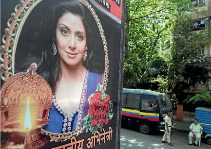  ?? PHOTO: AP ?? Policemen stand guard outside Indian actress Sridevi Kapoor’s residence in Mumbai, near tributes left by fans.