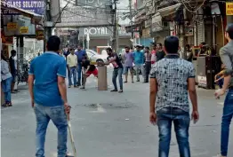  ?? — PTI, G. N. JHA ?? Shop owners ( above) play cricket after they closed their stores in protest against the sealing in New Delhi on Tuesday. A shop is seen locked in South Delhi’s Amar Colony Market.