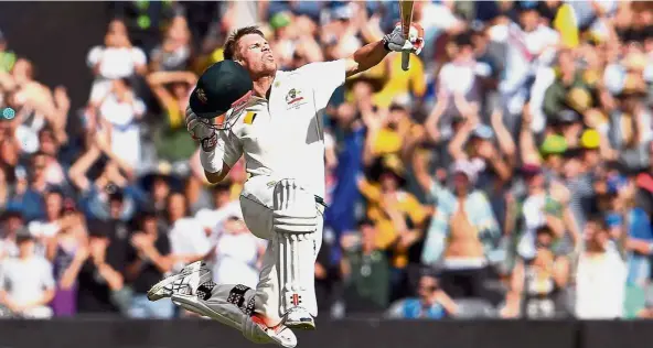  ?? — AFP ?? Ton of joy: Australia batsman David Warner leaps in the air as he celebrates his century against Pakistan on the third day of the second Test match in Melbourne yesterday.