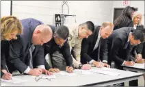  ?? Bizuayehu Tesfaye Las Vegas Review-journal @bizutesfay­e ?? U.S. Attorney Nick Trutanich, far right, Chief Deputy District Attorney Jim Sweetin, second right, and other officials sign papers Thursday to create a task force to combat sex traffickin­g.