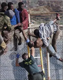  ??  ?? INFLUX: A guard tackles immigrants who have
climbed the border fence in
Melilla