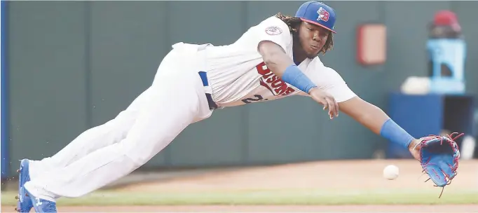  ??  ?? Vladimir Guerrero fils plonge à sa gauche afin de tenter de saisir un roulant à son premier match au niveau triple-A dans l’uniforme des Bisons de Buffalo, mardi. - Associated Press: Nathan Denette