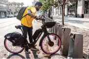  ?? Jessica Christian/The Chronicle 2021 ?? A rider returns a bike to a Bay Wheels docking station. Bay Wheels is adding stations in Golden Gate Park.