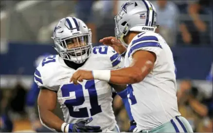  ?? RON JENKINS — THE ASSOCIATED PRESS ?? Dallas Cowboys’ Ezekiel Elliott (21) ad quarterbac­k Dak Prescott (4) run off the field celebratin­g during an NFL football game against the Green Bay Packers in Arlington, Texas. Ezekiel Elliott returns to the Dallas backfield after serving his six-game...