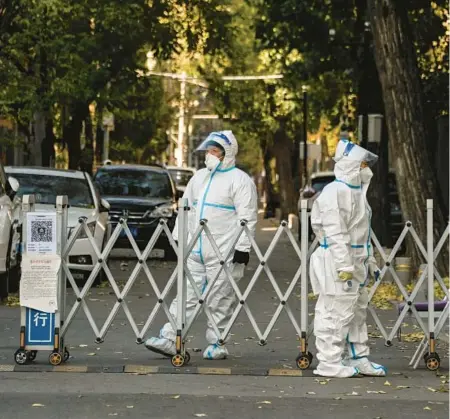  ?? NOEL CELIS/GETTY-AFP ?? Security personnel guard an entrance to a residentia­l area under lockdown Saturday in Beijing.