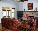  ??  ?? The great room has a lofty tray ceiling and centers around a rock gas-log  replace.