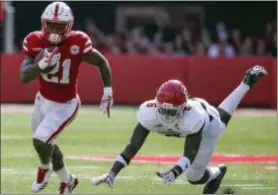  ?? THE ASSOCIATED PRESS ?? Nebraska running back Mikale Wilbon (21) runs past a tackle attempt by Rutgers linebacker Deonte Roberts (6) during the first half.