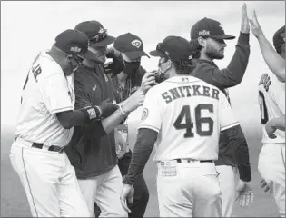  ?? KEVORK DJANSEZIAN/GETTY-AFP PHOTOS ?? Manager Dusty Baker, left, celebrates with Astros players and coaches after eliminatin­g the A’s on Thursday.