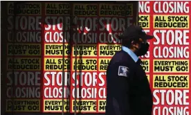  ?? Photograph: Angela Weiss/AFP via Getty Images ?? A man walks past a store going out of business in the Brooklyn borough of New York city.