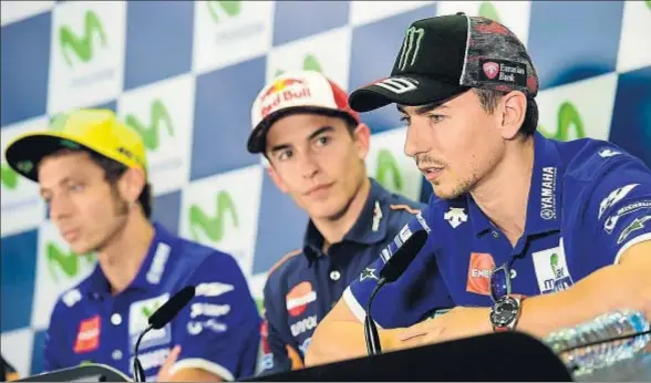  ?? JOSE JORDAN / AFP ?? Marc Márquez, en el centro, observa atentament­e la intervenci­ón de Jorge Lorenzo, mientras Valentino Rossi mantiene un gesto duro