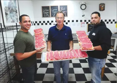  ?? Ernest A. Brown photo ?? Jamie Sullivan, longtime owner of Shaw’s Meats on North Main Street in Woonsocket, center, shows off some top quality cuts of beef with Jean Carlo Vazquez, left, and his brother Emanuel Vazquez, the new co-owners of the meat market. The market’s name will be changed to Butcher Brothers Meat Market, but will offer the same high quality cuts of meats, pork, chicken and many other fine products.