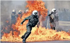  ?? ?? A petrol bomb explodes near riot police as they clash with protesters in Athens