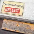  ??  ?? Ein Schild mit der Aufschrift „Ferienwohn­ung belegt“an der Hauswand einer Pension in Berchtesga­den.